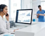 Physical therapy clinic receptionist answering a patient phone call while monitoring call tracking analytics and marketing performance data